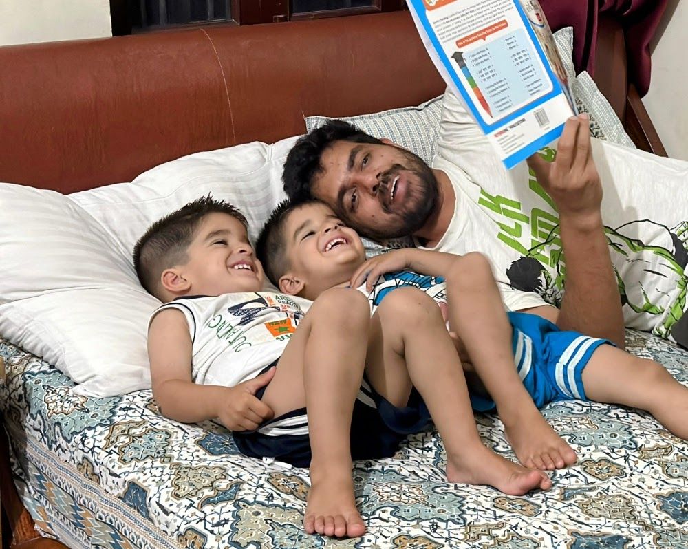 Surendra reading to his twin boys